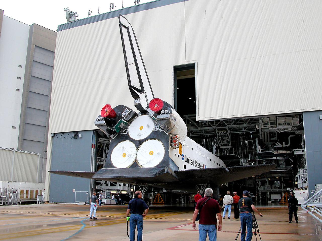 KENNEDY SPACE CENTER, FLA. - The Space Shuttle orbiter Atlantis backs out of the Orbiter Processing Facility (OPF) for its move to the Vehicle Assembly Building (VAB). The move will allow work to be performed in the OPF that can only be accomplished while the bay is empty. Work scheduled in the processing facility includes annual validation of the bay's cranes, work platforms, lifting mechanisms, and jack stands. Atlantis will remain in the VAB for about 10 days, then return to the OPF as work resumes to prepare it for launch in September 2004 on the first return-to-flight mission, STS-114.