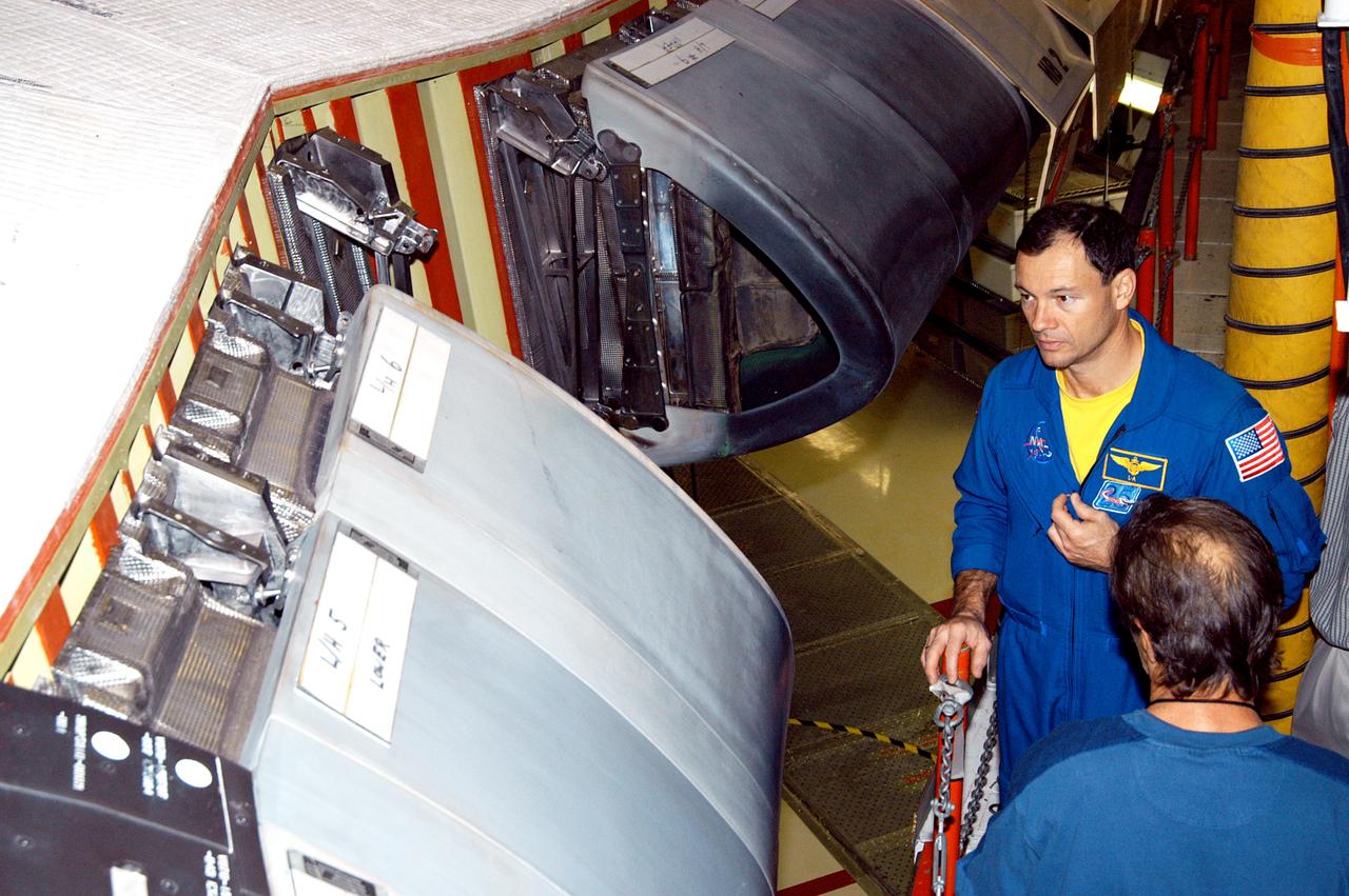 KENNEDY SPACE CENTER, FLA. - In the Orbiter Processing Facility, astronaut Michael E. Lopez-Alegria looks at the Reinforced Carbon Carbon panels used on the leading edge of the wing of the orbiters. He and engineers from around the Agency are on a fact-finding tour for improving the RCC panels used on the wing leading edge.  The gray carbon composite RCC panels have sufficient strength to withstand the aerodynamic forces experienced during launch and reentry, which can reach as high as 800 pounds per square foot.  The operating range of RCC is from minus 250º F to about 3,000º F, the temperature produced by friction with the atmosphere during reentry.
