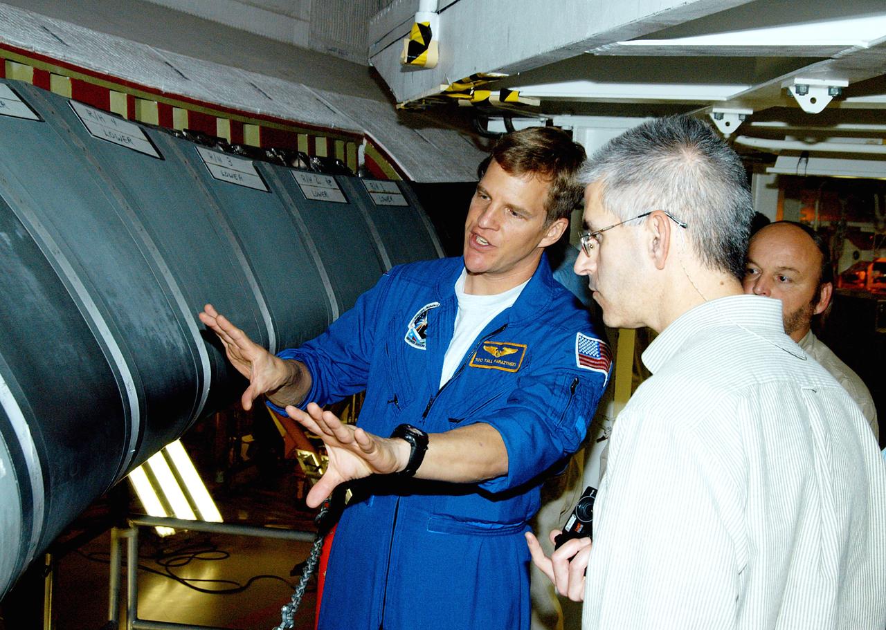 KENNEDY SPACE CENTER, FLA. -  In the Orbiter Processing Facility, astronaut Scott E. Parazynski discusses the Reinforced Carbon Carbon panels used on the leading edge of the wing of the orbiters.  With him are engineers from around the Agency who are working on improving the RCC panels used on the wing leading edge. The gray carbon composite RCC panels have sufficient strength to withstand the aerodynamic forces experienced during launch and reentry, which can reach as high as 800 pounds per square foot.  The operating range of RCC is from minus 250º F to about 3,000º F, the temperature produced by friction with the atmosphere during reentry.