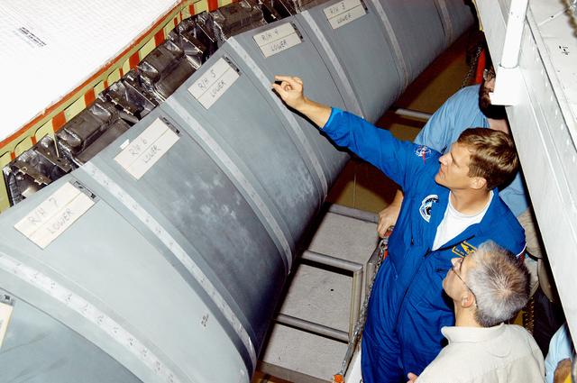 NASA image: KENNEDY SPACE CENTER, FLA. -  In the Orbiter Processing Facility, astronaut Scott E. Parazynski points to the Reinforced Carbon Carbon panels used on the leading edge of the wing of the orbiters. With Parazynski are engineers from around the Agency who are working on improving the RCC panels used on the wing leading edge.  The gray carbon composite RCC panels have sufficient strength to withstand the aerodynamic forces experienced during launch and reentry, which can reach as high as 800 pounds per square foot.  The operating range of RCC is from minus 250º F to about 3,000º F, the temperature produced by friction with the atmosphere during reentry.