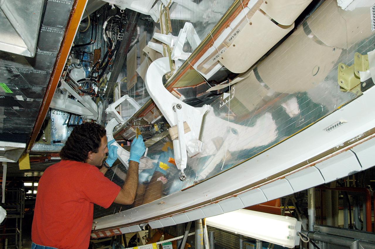 KENNEDY SPACE CENTER, FLA. -  In the Orbiter Processing Facility, KSC employee Gene Peavler works in the wheel area on the orbiter Discovery.  The vehicle has undergone Orbiter Major Modifications in the past year.  Discovery is scheduled to fly on mission STS-121 to the International Space Station.