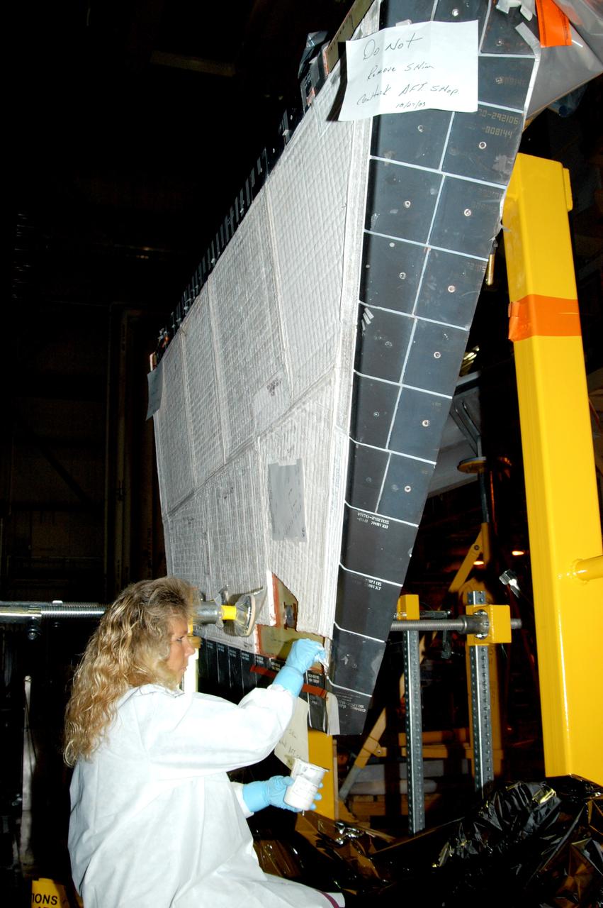 KENNEDY SPACE CENTER, FLA. -  In the Orbiter Processing Facility, KSC employee Nadine Phillips prepares an area on the orbiter Discovery for blanket installation.  The blankets are part of the Orbiter Thermal Protection System, thermal shields to protect against temperatures as high as 3,000° Fahrenheit, which are produced during descent for landing. Discovery is scheduled to fly on mission STS-121 to the International Space Station.