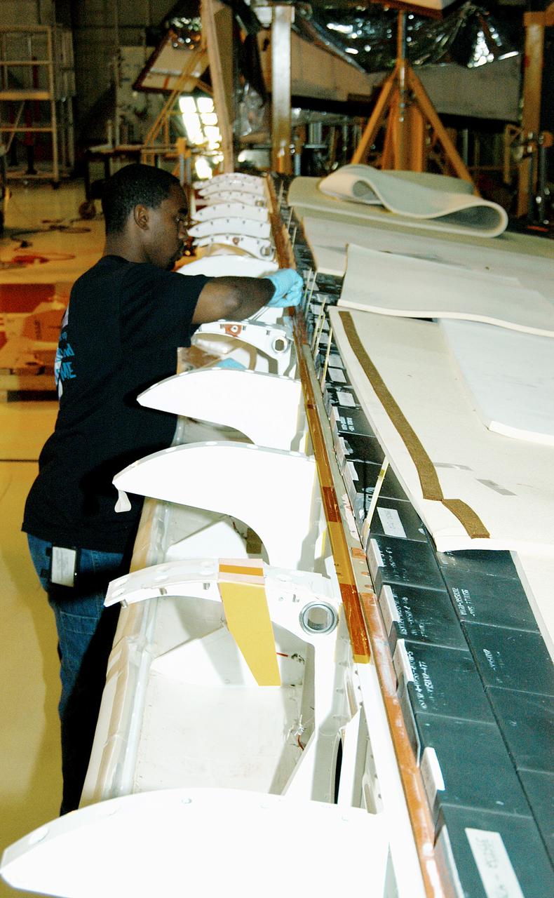 KENNEDY SPACE CENTER, FLA. -  In the Orbiter Processing Facility, KSC employee Duane Williams prepares the blanket insulation to be installed on the body flap on orbiter Discovery.  The blankets are part of the Orbiter Thermal Protection System, thermal shields to protect against temperatures as high as 3,000° Fahrenheit, which are produced during descent for landing. Discovery is scheduled to fly on mission STS-121 to the International Space Station.