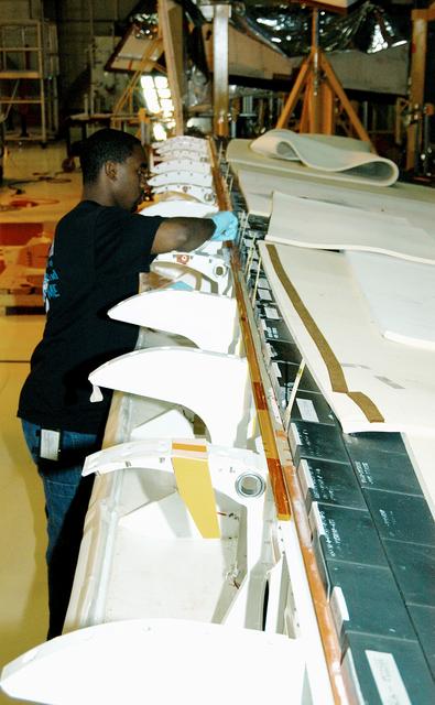 NASA image: KENNEDY SPACE CENTER, FLA. -  In the Orbiter Processing Facility, KSC employee Duane Williams prepares the blanket insulation to be installed on the body flap on orbiter Discovery.  The blankets are part of the Orbiter Thermal Protection System, thermal shields to protect against temperatures as high as 3,000° Fahrenheit, which are produced during descent for landing. Discovery is scheduled to fly on mission STS-121 to the International Space Station.