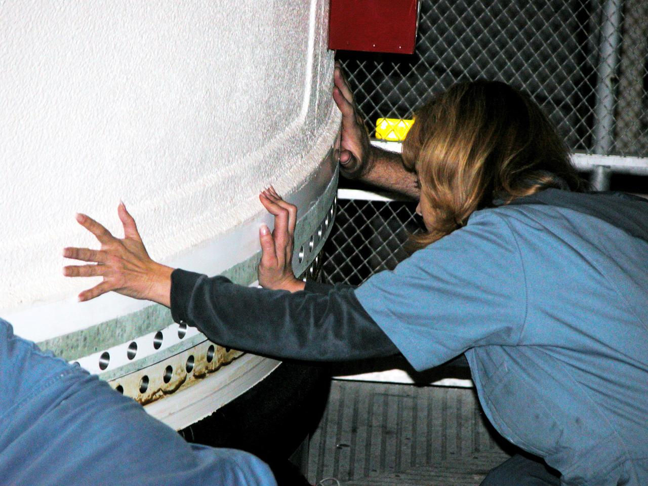 KENNEDY SPACE CENTER, FLA. -  In the Vehicle Assembly Building, a KSC employee separates the forward assembly (nose cap and frustum) from a solid rocket booster (SRB) after the bolts were removed.  The destacking is part of time and cycle activities.  The SRB was part of the stack on Atlantis originally scheduled for a March 1, 2003, launch on mission STS-114.  The SRBs and external tank were demated in February 2003.   The mission is now scheduled to occur no earlier than Sept. 12, 2004, on Atlantis.
