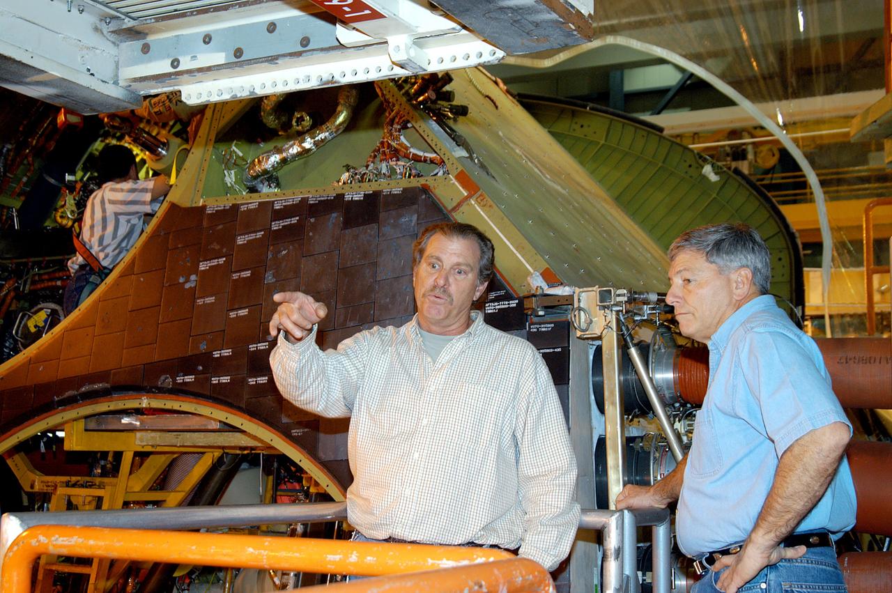 KENNEDY SPACE CENTER, FLA. -- NASA Deputy Associate Administrator for Space Station and Shuttle Programs Michael Kostelnik (right) discusses a speed brake on Shuttle Discovery in Orbiter Processing Facility Bay 3 with a United Space Alliance (USA) technician (left).  NASA and USA Space Shuttle program management are participating in a leadership workday.  The day is intended to provide management with an in-depth, hands-on look at Shuttle processing activities at KSC.