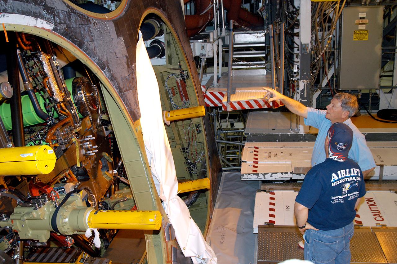 KENNEDY SPACE CENTER, FLA. -- NASA Deputy Associate Administrator for Space Station and Shuttle Programs Michael Kostelnik (top) discusses the inner workings of Shuttle Atlantis in Orbiter Processing Facility Bay 1 with a United Space Alliance (USA) technician (bottom).  NASA and USA Space Shuttle program management are participating in a leadership workday.  The day is intended to provide management with an in-depth, hands-on look at Shuttle processing activities at KSC.