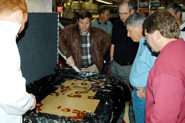 NASA image: KENNEDY SPACE CENTER, FLA. -- From left, a United Space Alliance (USA) technician briefs NASA Deputy Program Manager of the Space Shuttle Program Michael Wetmore, USA Vice President and Space Shuttle Program Manager Howard DeCastro, and NASA Deputy Associate Administrator for Space Station and Shuttle Programs Michael Kostelnik on the use of cold plates in Orbiter Processing Facility Bay 2.  NASA and USA Space Shuttle program management are participating in a leadership workday.  The day is intended to provide management with an in-depth, hands-on look at Shuttle processing activities at KSC.