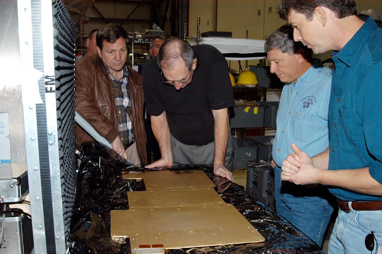 KENNEDY SPACE CENTER, FLA. -- From left, NASA Deputy Program Manager of the Space Shuttle Program Michael Wetmore, United Space Alliance (USA) Vice President and Space Shuttle Program Manager Howard DeCastro, NASA Deputy Associate Administrator for Space Station and Shuttle Programs Michael Kostelnik, and a USA technician examine cold plates in Orbiter Processing Facility Bay 2.  NASA and USA Space Shuttle program management are participating in a leadership workday.  The day is intended to provide management with an in-depth, hands-on look at Shuttle processing activities at KSC.