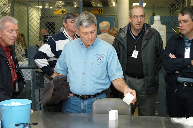 NASA image: KENNEDY SPACE CENTER, FLA. -- From left, United Space Alliance (USA) Deputy Space Shuttle Program Manager of Operations Loren Shriver, USA Associate Program Manager of Ground Operations Andy Allen, NASA Deputy Associate Administrator for Space Station and Shuttle Programs Michael Kostelnik, and USA Vice President and Space Shuttle Program Manager Howard DeCastro examine a tile used in the Shuttle's Thermal Protection System (TPS) in KSC's TPS Facility.  NASA and USA Space Shuttle program management are participating in a leadership workday.  The day is intended to provide management with an in-depth, hands-on look at Shuttle processing activities at KSC.
