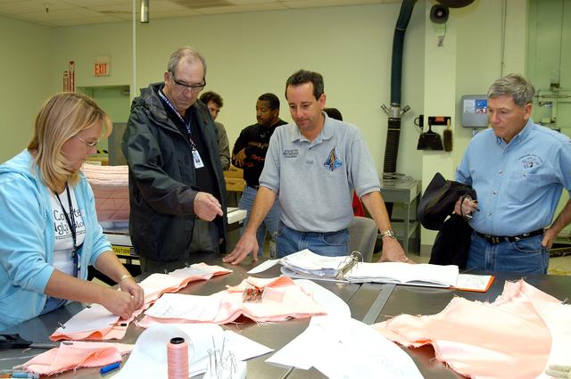 NASA image: KENNEDY SPACE CENTER, FLA. -- United Space Alliance (USA) technicians demonstrate the construction of a thermal blanket used in the Shuttle's thermal protection system for USA Vice President and Space Shuttle Program Manager Howard DeCastro (second from left) and NASA Deputy Associate Administrator for Space Station and Shuttle Programs Michael Kostelnik (right).  NASA and USA Space Shuttle program management are participating in a leadership workday.  The day is intended to provide management with an in-depth, hands-on look at Shuttle processing activities at KSC.