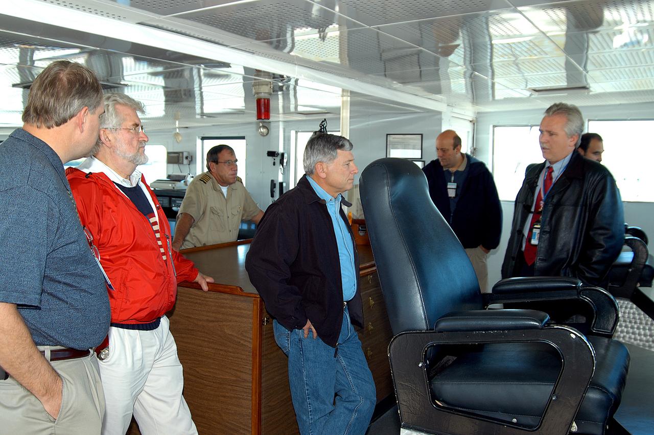 KENNEDY SPACE CENTER, FLA. -- NASA Deputy Associate Administrator for Space Station and Shuttle Programs Michael Kostelnik (center) is given a tour of a solid rocket booster (SRB) retrieval ship by United Space Alliance (USA) employee Joe Chaput (right).  NASA and USA Space Shuttle program management are participating in a leadership workday.  The day is intended to provide management with an in-depth, hands-on look at Shuttle processing activities at KSC.