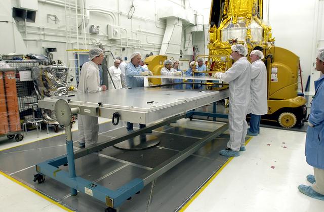 NASA image: VANDENBERG AFB, CALIF. - Workers in the NASA spacecraft processing facility on North Vandenberg Air Force Base prepare for the installation of solar array panel 3 on the Gravity Probe B spacecraft.  Installing each array is a 3-day process and includes a functional deployment test.  The Gravity Probe B mission is a relativity experiment developed by NASA’s Marshall Space Flight Center, Stanford University and Lockheed Martin.  The spacecraft will test two extraordinary predictions of Albert Einstein’s general theory of relativity that he advanced in 1916: the geodetic effect (how space and time are warped by the presence of the Earth) and frame dragging (how Earth’s rotation drags space and time around with it).  Gravity Probe B consists of four sophisticated gyroscopes that will provide an almost perfect space-time reference system.  The mission will look in a precision manner for tiny changes in the direction of spin.