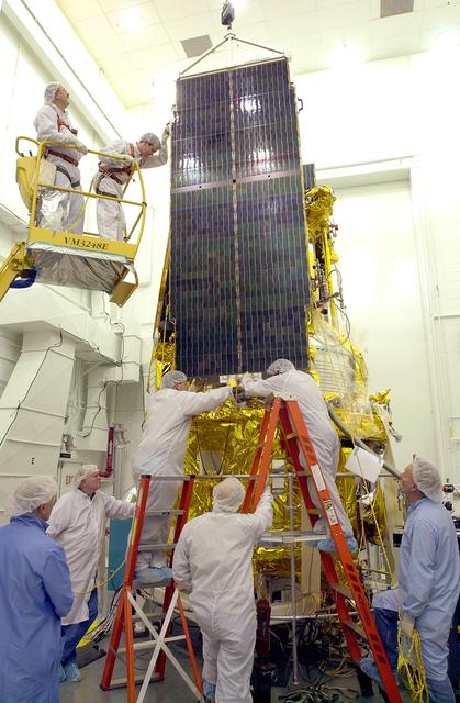 NASA image: VANDENBERG AFB, CALIF. - Workers in the NASA spacecraft processing facility on North Vandenberg Air Force Base attach a solar array panel on the Gravity Probe B spacecraft.  Installing each array is a 3-day process and includes a functional deployment test.  The Gravity Probe B mission is a relativity experiment developed by NASA’s Marshall Space Flight Center, Stanford University and Lockheed Martin.  The spacecraft will test two extraordinary predictions of Albert Einstein’s general theory of relativity that he advanced in 1916: the geodetic effect (how space and time are warped by the presence of the Earth) and frame dragging (how Earth’s rotation drags space and time around with it).  Gravity Probe B consists of four sophisticated gyroscopes that will provide an almost perfect space-time reference system.  The mission will look in a precision manner for tiny changes in the direction of spin.
