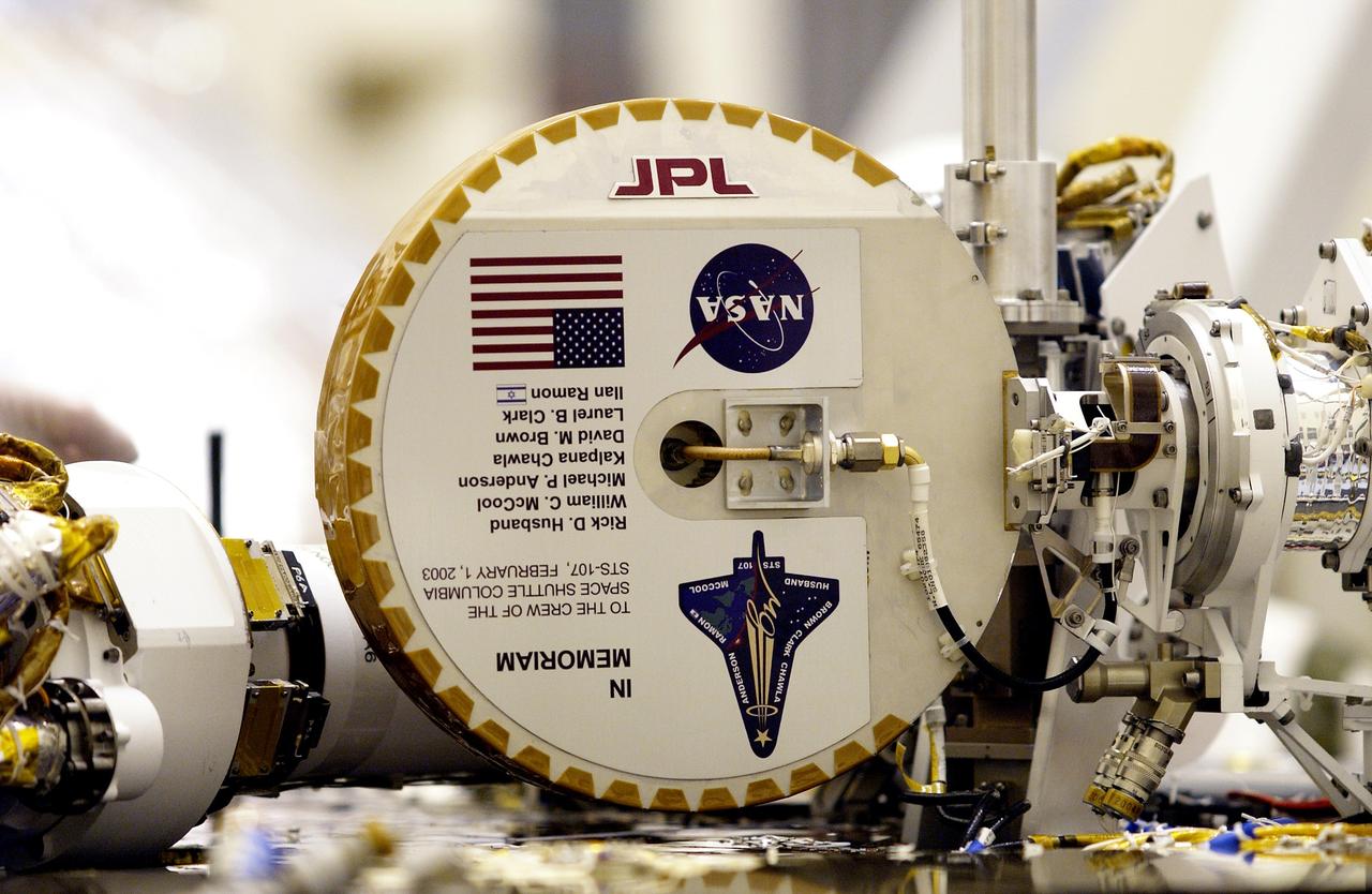 KENNEDY SPACE CENTER, FLA. -- This plaque commemorating the STS-107 Space Shuttle Columbia crew now looks over the Mars landscape after the successful landing and deployment of the Mars Exploration Rover “Spirit” Jan. 4 onto the red planet.  The plaque, mounted on the high-gain antenna, is shown while the rover underwent final checkout March 28, 2003, in the Payload Hazardous Servicing Facility at KSC.