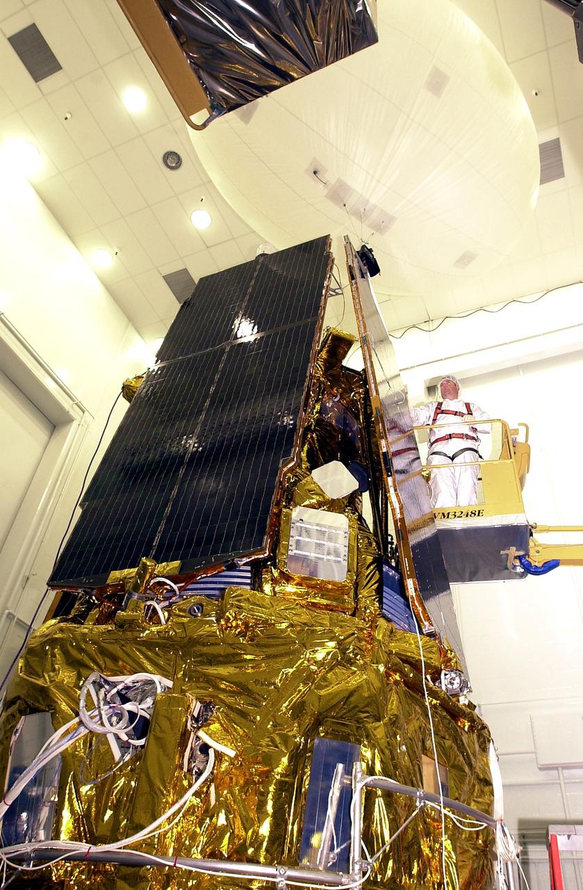 VANDENBERG AFB, CALIF. - In the NASA spacecraft processing facility on North Vandenberg Air Force Base, a worker checks the installation of a solar array panel onto the Gravity Probe B spacecraft. Installing each array is a 3-day process and includes a functional deployment test. The Gravity Probe B mission is a relativity experiment developed by NASA’s Marshall Space Flight Center, Stanford University and Lockheed Martin. The spacecraft will test two extraordinary predictions of Albert Einstein’s general theory of relativity that he advanced in 1916: the geodetic effect (how space and time are warped by the presence of the Earth) and frame dragging (how Earth’s rotation drags space and time around with it). Gravity Probe B consists of four sophisticated gyroscopes that will provide an almost perfect space-time reference system. The mission will look in a precision manner for tiny changes in the direction of spin.