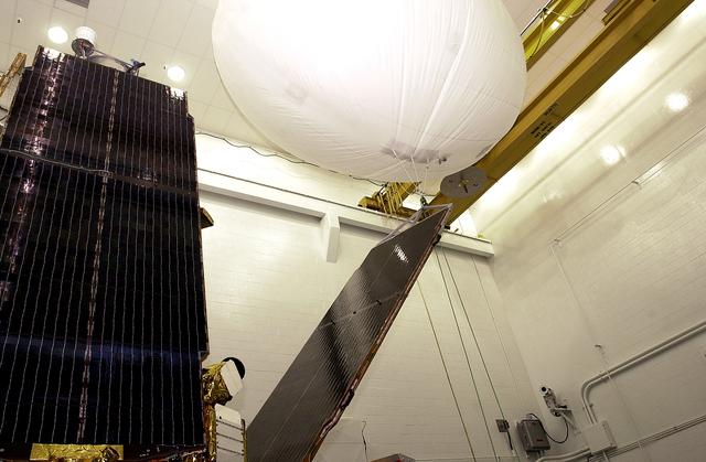 NASA image: VANDENBERG AFB, CALIF. -  In the NASA spacecraft processing facility on North Vandenberg Air Force Base, a balloon gently lifts the solar array panel to be installed on the Gravity Probe B spacecraft.  Installing each array is a 3-day process and includes a functional deployment test.  The Gravity Probe B mission is a relativity experiment developed by NASA’s Marshall Space Flight Center, Stanford University and Lockheed Martin.  The spacecraft will test two extraordinary predictions of Albert Einstein’s general theory of relativity that he advanced in 1916: the geodetic effect (how space and time are warped by the presence of the Earth) and frame dragging (how Earth’s rotation drags space and time around with it).  Gravity Probe B consists of four sophisticated gyroscopes that will provide an almost perfect space-time reference system.  The mission will look in a precision manner for tiny changes in the direction of spin.