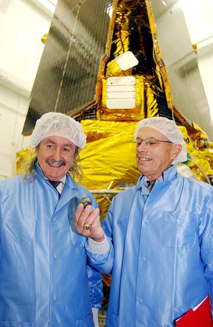 NASA image: VANDENBERG AFB, CALIF. -  In the NASA spacecraft processing facility on North Vandenberg Air Force Base,  Dr. Francis Everitt, principal investigator, and Brad Parkinson, co-principal investigator, both from Stanford University, hold one of the small gyroscopes used in the Gravity Probe B spacecraft.  The GP-B towers behind them.  The Gravity Probe B mission is a relativity experiment developed by NASA’s Marshall Space Flight Center, Stanford University and Lockheed Martin.  The spacecraft will test two extraordinary predictions of Albert Einstein’s general theory of relativity that he advanced in 1916: the geodetic effect (how space and time are warped by the presence of the Earth) and frame dragging (how Earth’s rotation drags space and time around with it).  Gravity Probe B consists of four sophisticated gyroscopes that will provide an almost perfect space-time reference system.  The mission will look in a precision manner for tiny changes in the direction of spin.