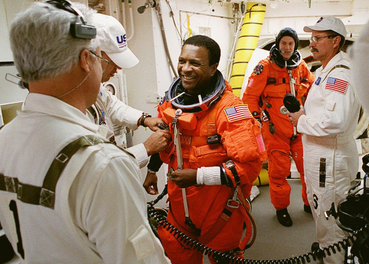 KENNEDY SPACE CENTER, FLA. -- STS-107 Payload Commander Michael Anderson gets help with his launch and entry suit from the Closeout Crew in the White Room. The environmentally controlled chamber is mated to Space Shuttle Columbia for entry into the Shuttle. Behind him is Pilot William "Willie" McCool. STS-107 is a mission devoted to research and will include more than 80 experiments that will study Earth and space science, advanced technology development, and astronaut health and safety. The payload on Space Shuttle Columbia includes FREESTAR (Fast Reaction Experiments Enabling Science, Technology, Applications and Research) and the SHI Research Double Module (SHI/RDM), known as SPACEHAB. Experiments on the module range from material sciences to life sciences. Liftoff is scheduled for 10:39 a.m. EST.