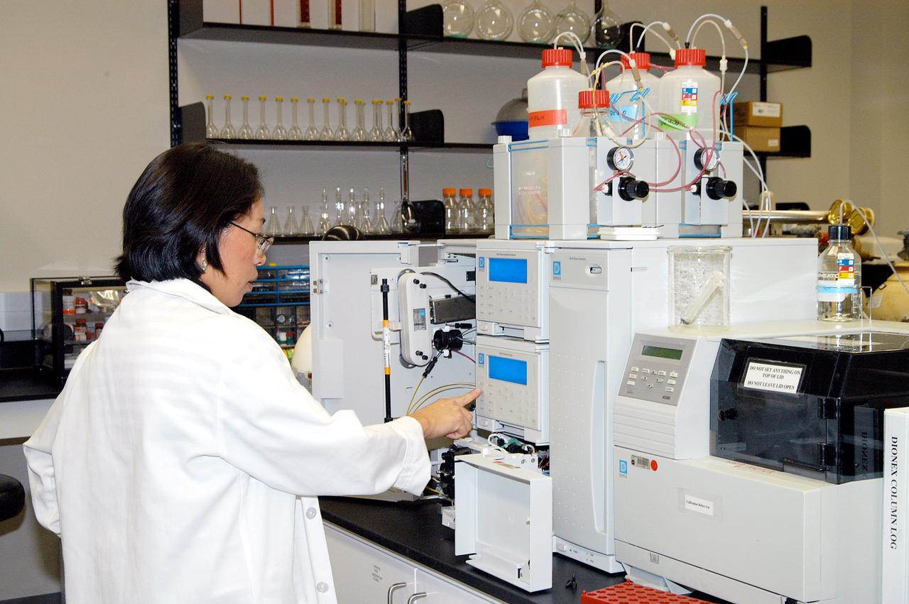 KENNEDY SPACE CENTER, FLA. -- Lanfang Levine, with Dynamac Corp., helps install a Dionex DX-500 IC/HPLC system  in the Space Life Sciences Lab.  The equipment will enable analysis of volatile compounds, such as from plants. The 100,000 square-foot facility houses labs for NASA’s ongoing research efforts, microbiology/microbial ecology studies and analytical chemistry labs. Also calling the new lab home are facilities for space flight-experiment and flight-hardware development, new plant growth chambers, and an Orbiter Environment Simulator that will be used to conduct ground control experiments in simulated flight conditions for space flight experiments.  The SLS Lab, formerly known as the Space Experiment Research and Processing Laboratory or SERPL, provides space for NASA’s Life Sciences Services contractor Dynamac Corporation, Bionetics Corporation, and researchers from the University of Florida. NASA’s Office of Biological and Physical Research will use the facility for processing life sciences experiments that will be conducted on the International Space Station. The SLS Lab is the magnet facility for the International Space Research Park at KSC being developed in partnership with Florida Space Authority.