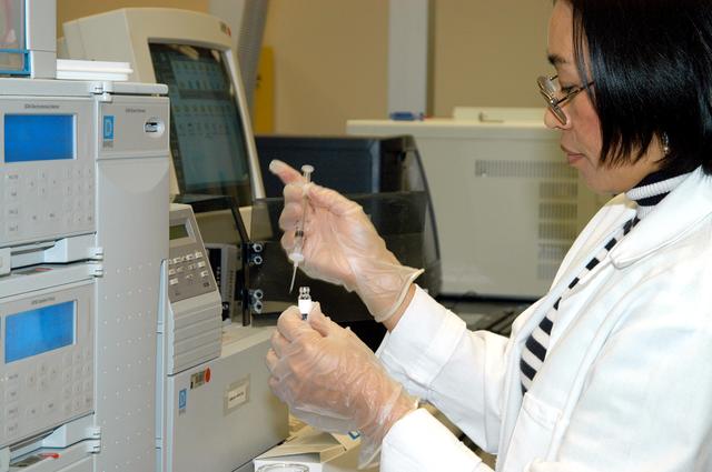NASA image: KENNEDY SPACE CENTER, FLA. -- In the Space Life Sciences Lab, Lanfang Levine, with Dynamac Corp., transfers material into a sample bottle for analysis.  She is standing in front of new equipment in the lab that will provide gas chromatography and mass spectrometry.  The equipment will enable analysis of volatile compounds, such as from plants.  The 100,000 square-foot facility houses labs for NASA’s ongoing research efforts, microbiology/microbial ecology studies and analytical chemistry labs. Also calling the new lab home are facilities for space flight-experiment and flight-hardware development, new plant growth chambers, and an Orbiter Environment Simulator that will be used to conduct ground control experiments in simulated flight conditions for space flight experiments.  The SLS Lab, formerly known as the Space Experiment Research and Processing Laboratory or SERPL, provides space for NASA’s Life Sciences Services contractor Dynamac Corporation, Bionetics Corporation, and researchers from the University of Florida. NASA’s Office of Biological and Physical Research will use the facility for processing life sciences experiments that will be conducted on the International Space Station. The SLS Lab is the magnet facility for the International Space Research Park at KSC being developed in partnership with Florida Space Authority.