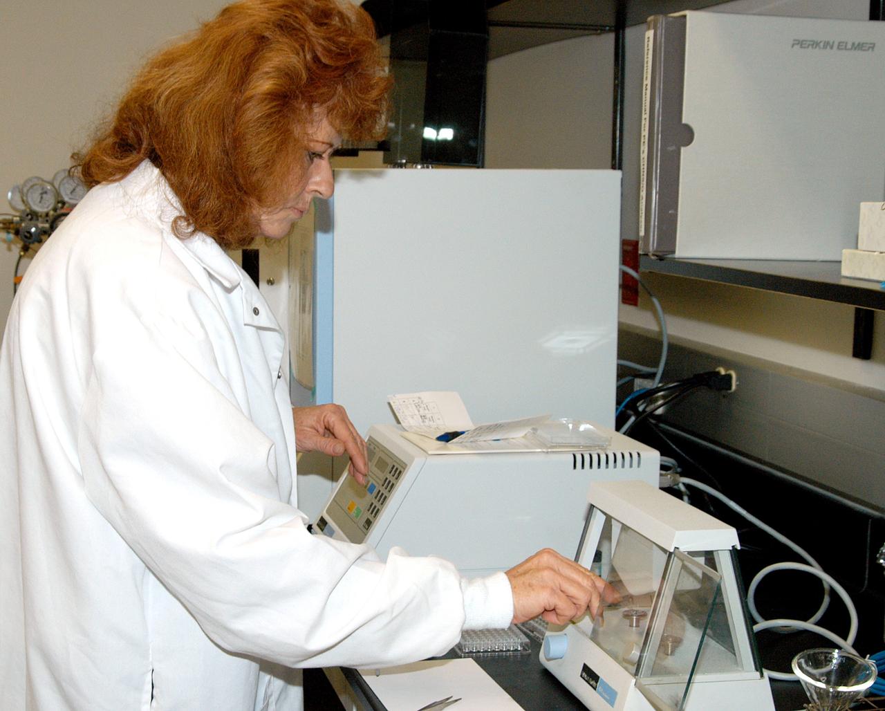 KENNEDY SPACE CENTER, FLA. -- In the Space Life Sciences (SLS) Lab, Jan Bauer, with Dynamac Corp., places samples of onion tissue in the elemental analyzer, which analyzes for carbon, hydrogen, nitrogen and sulfur. The 100,000 square-foot SLS houses labs for NASA’s ongoing research efforts, microbiology/microbial ecology studies and analytical chemistry labs. Also calling the new lab home are facilities for space flight-experiment and flight-hardware development, new plant growth chambers, and an Orbiter Environment Simulator that will be used to conduct ground control experiments in simulated flight conditions for space flight experiments.  The SLS Lab, formerly known as the Space Experiment Research and Processing Laboratory or SERPL, provides space for NASA’s Life Sciences Services contractor Dynamac Corporation, Bionetics Corporation, and researchers from the University of Florida. NASA’s Office of Biological and Physical Research will use the facility for processing life sciences experiments that will be conducted on the International Space Station. The SLS Lab is the magnet facility for the International Space Research Park at KSC being developed in partnership with Florida Space Authority.