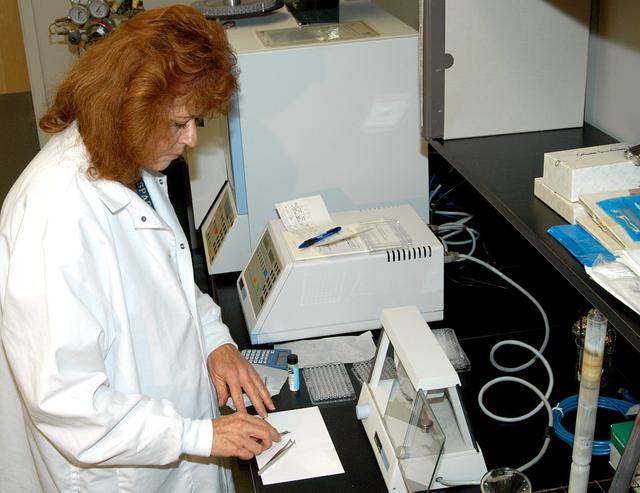 NASA image: KENNEDY SPACE CENTER, FLA. -- In the Space Life Sciences (SLS) Lab, Jan Bauer, with Dynamac Corp., weighs samples of onion tissue for processing in the elemental analyzer behind it.  The equipment analyzes for carbon, hydrogen, nitrogen and sulfur. The 100,000 square-foot SLS houses labs for NASA’s ongoing research efforts, microbiology/microbial ecology studies and analytical chemistry labs. Also calling the new lab home are facilities for space flight-experiment and flight-hardware development, new plant growth chambers, and an Orbiter Environment Simulator that will be used to conduct ground control experiments in simulated flight conditions for space flight experiments.  The SLS Lab, formerly known as the Space Experiment Research and Processing Laboratory or SERPL, provides space for NASA’s Life Sciences Services contractor Dynamac Corporation, Bionetics Corporation, and researchers from the University of Florida. NASA’s Office of Biological and Physical Research will use the facility for processing life sciences experiments that will be conducted on the International Space Station. The SLS Lab is the magnet facility for the International Space Research Park at KSC being developed in partnership with Florida Space Authority.