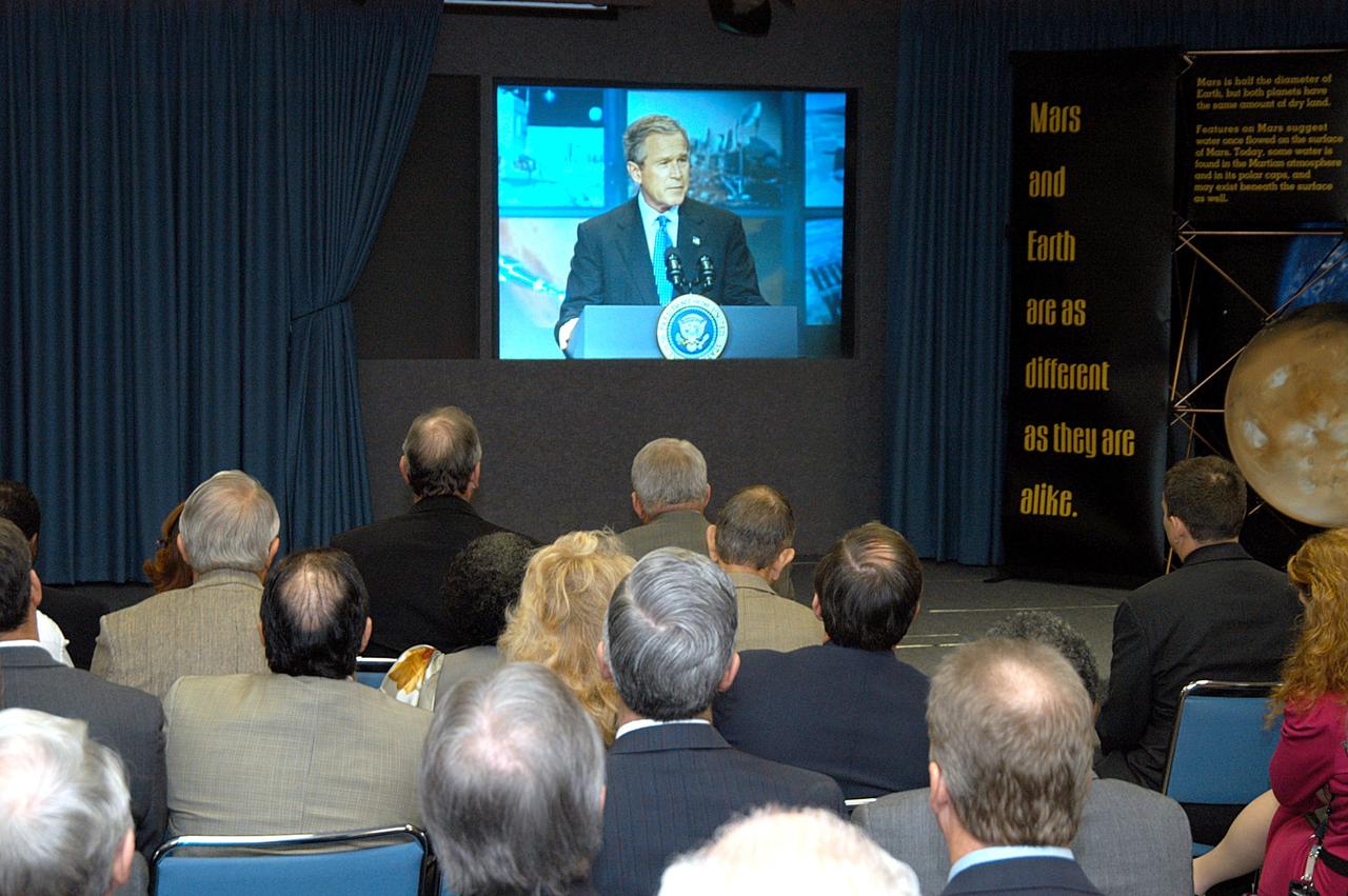 KENNEDY SPACE CENTER, FLA. -- KSC management and other employees gather in the Center’s television studio to watch the address by President George W. Bush at NASA Headquarters in Washington, D.C., stating his goals for NASA’s new mission:  Completing the International Space Station, retiring the Space Shuttle orbiters, developing a new crew exploration vehicle, and returning to the moon and beyond within the next two decades.   Pres. Bush was welcomed by NASA Administrator Sean O’Keefe and Expedition 8 Commander Michael Foale, who greeted him from the International Space Station.  Members of the Washington, D.C., audience included astronauts Eileen Collins, Ed Lu and Michael Lopez-Alegria, and former astronaut Gene Cernan.