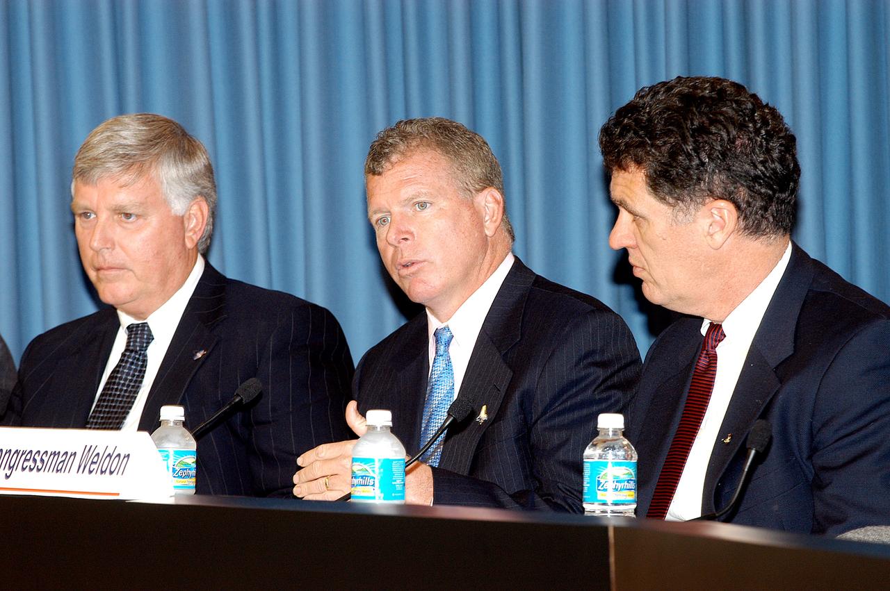 KENNEDY SPACE CENTER, FLA. -- At a press conference, U.S. Rep. Tom Feeney responds to a question from a reporter about the new mission for NASA outlined by President George W. Bush Jan. 14.  Present with Feeney are Center Director Jim Kennedy (left) and U.S. Rep. Dave Weldon (right).