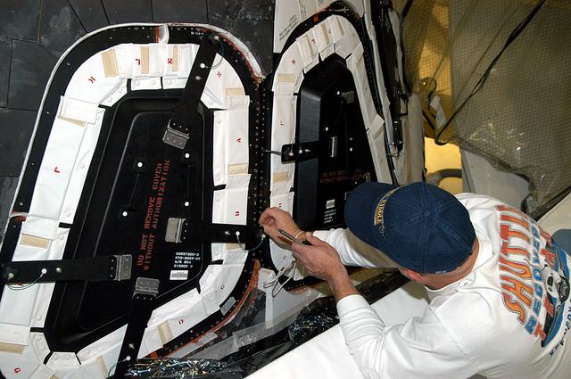 NASA image: KENNEDY SPACE CENTER, FLA. -- Les Hanks, with United Space Alliance, prepares a window on Atlantis for removal.  The windows are being removed to inspect them for contaminants in the thermal seal.  Atlantis has been undergoing routine maintenance in the Orbiter Processing Facility for Return to Flight, on mission STS-114.