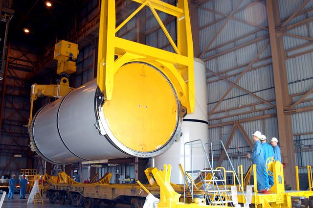 NASA image: KENNEDY SPACE CENTER, FLA. -  In the Rotation Processing and Surge Facility, an SRB solid segment is lowered onto a rail car for shipment to Utah where it will be tested.  The segment was part of the STS-114 stack.  It is the first time actual flight segments that had been stacked for flight in the VAB are being returned to Utah for testing.  It will undergo firing, which will enable inspectors to check the viability of the solid and verify the life expectancy for stacked segments.
