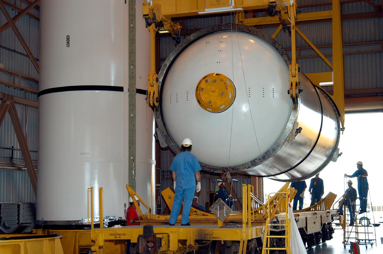 KENNEDY SPACE CENTER, FLA. -  In the Rotation Processing and Surge Facility, an SRB solid segment is lowered onto a rail car for shipment to Utah where it will be tested.  The segment was part of the STS-114 stack.  It is the first time actual flight segments that had been stacked for flight in the VAB are being returned to Utah for testing.  It will undergo firing, which will enable inspectors to check the viability of the solid and verify the life expectancy for stacked segments.