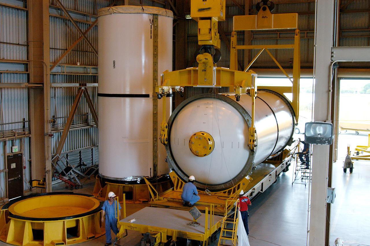 KENNEDY SPACE CENTER, FLA. -  In the Rotation Processing and Surge Facility, an SRB solid segment is lowered onto a rail car for shipment to Utah where it will be tested.  The segment was part of the STS-114 stack.  It is the first time actual flight segments that had been stacked for flight in the VAB are being returned to Utah for testing.  It will undergo firing, which will enable inspectors to check the viability of the solid and verify the life expectancy for stacked segments.