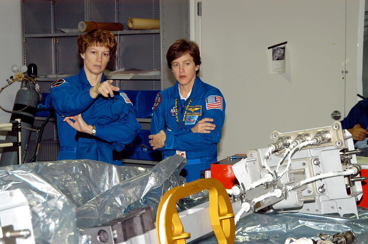 KENNEDY SPACE CENTER, FLA. -  STS-114 Commander Eileen Collins and Mission Specialist Wendy Lawrence look over mission equipment in the Space Station Processing Facility.  Crew members are at KSC for equipment familiarization.  STS-114 is classified as Logistics Flight 1 to the International Space Station, delivering new supplies and replacing one of the orbital outpost’s Control Moment Gyroscopes (CMGs). STS-114 will also carry a Raffaello Multi-Purpose Logistics Module and the External Stowage Platform-2.  The crew is slated to conduct at least three spacewalks: They will demonstrate repair techniques of the Shuttle’s Thermal Protection System,  replace the failed CMG with one delivered by the Shuttle, and  install the External Stowage Platform.