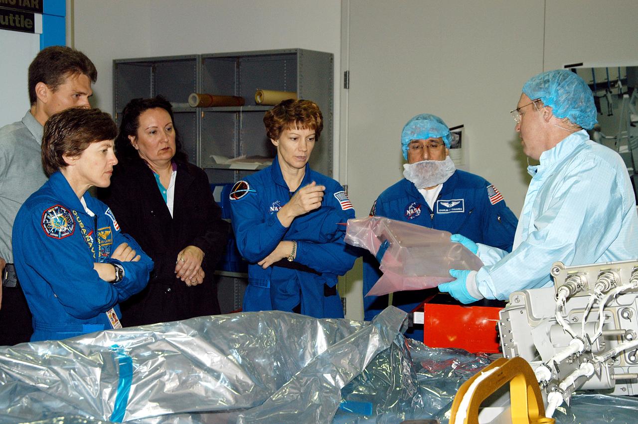 KENNEDY SPACE CENTER, FLA. -  STS-114 Mission Specialist Andrew Thomas (right) shows some of the mission equipment to other crew members (from left) Wendy Lawrence, mission specialist; Eileen Collins, commander; and Charles Camarda, mission specialist.  Crew members are at KSC for equipment familiarization.  STS-114 is classified as Logistics Flight 1 to the International Space Station, delivering new supplies and replacing one of the orbital outpost’s Control Moment Gyroscopes (CMGs). STS-114 will also carry a Raffaello Multi-Purpose Logistics Module and the External Stowage Platform-2.  The crew is slated to conduct at least three spacewalks: They will demonstrate repair techniques of the Shuttle’s Thermal Protection System,  replace the failed CMG with one delivered by the Shuttle, and  install the External Stowage Platform.