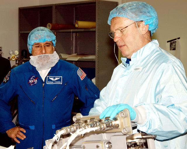NASA image: KENNEDY SPACE CENTER, FLA. -  STS-114 Mission Specialist Charles Camarda (left) watches as Mission Specialist  Andrew Thomas manipulates equipment that will be used on the mission.  Crew members are at KSC for equipment familiarization.  STS-114 is classified as Logistics Flight 1 to the International Space Station, delivering new supplies and replacing one of the orbital outpost’s Control Moment Gyroscopes (CMGs). STS-114 will also carry a Raffaello Multi-Purpose Logistics Module and the External Stowage Platform-2.  The crew is slated to conduct at least three spacewalks: They will demonstrate repair techniques of the Shuttle’s Thermal Protection System,  replace the failed CMG with one delivered by the Shuttle, and  install the External Stowage Platform.