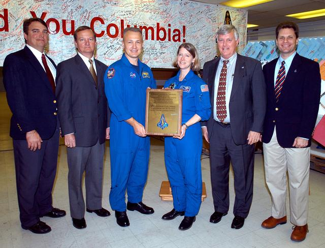 NASA image: KENNEDY SPACE CENTER, FLA. -  Posing with the plaque dedicated to Columbia Jan. 29, 2004,  are (left to right) United Space Alliance project leader for Columbia reconstruction Jim Comer, Shuttle Launch Director Mike Leinbach, astronauts Douglas Hurley and Pam Melroy, Center Director Jim Kennedy and NASA Vehicle Manager Scott Thurston.  The dedication of the plaque was made in front of the 40-member preservation team in the “Columbia room,” a permanent repository in the Vehicle Assembly Building of the debris collected in the aftermath of the tragic accident Feb. 1, 2003, that claimed the orbiter and lives of the seven-member crew.