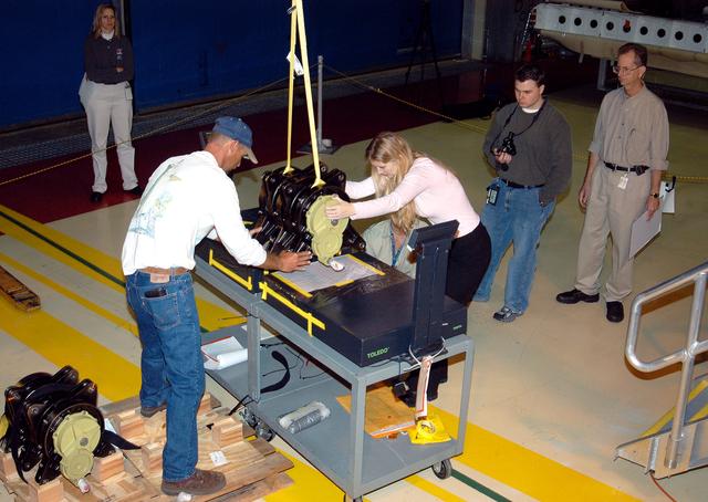 NASA image: KENNEDY SPACE CENTER, FLA. -  Workers in the Orbiter Processing Facility settle into place one of two rudder speed brake actuators onto a table to measure the alignment of its bearings.  The actuators move an orbiter’s rudder, speed brake, elevons and main engines during flight.