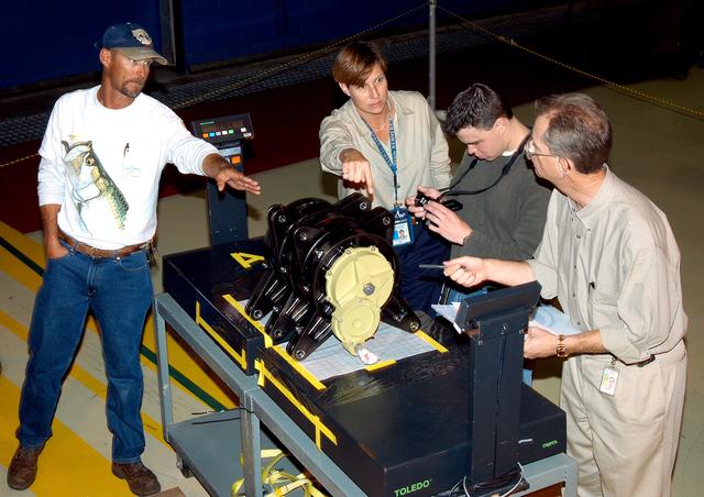 NASA image: KENNEDY SPACE CENTER, FLA. -   Workers in the Orbiter Processing Facility measure the alignment of bearings on a rudder speed brake actuator.  Actuators move an orbiter’s rudder, speed brake, elevons and main engines during flight.