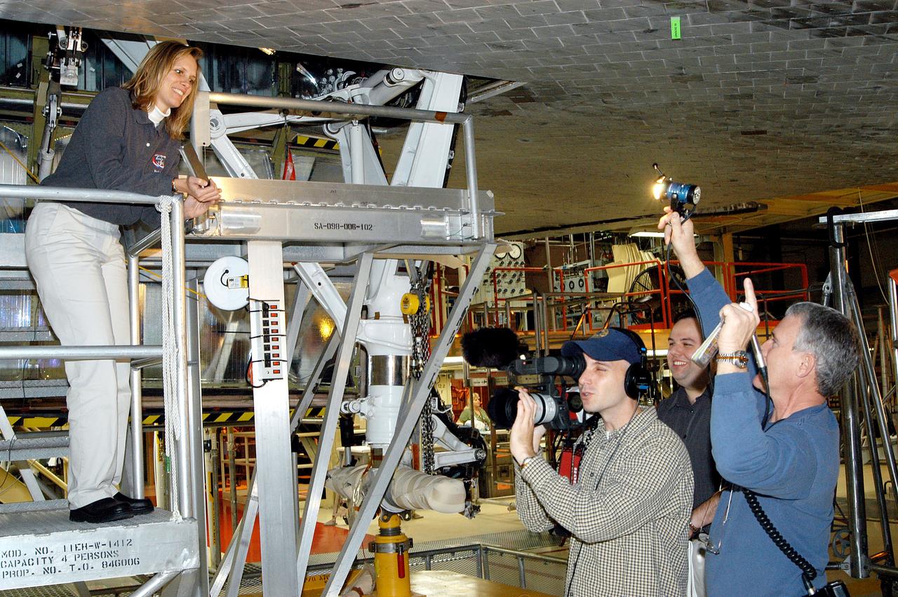 KENNEDY SPACE CENTER, FLA. -  Standing on a workstand (at left) in the Orbiter Processing Facility is Stephanie Stilson, NASA vehicle manager for Discovery.  She is being filmed for a special feature on the KSC Web about the recent Orbiter Major Modification period on Discovery, which included inspection, modifications and reservicing of most systems onboard, plus installation of a Multifunction Electronic Display Subsystem (MEDS) - a state-of-the-art “glass cockpit.”  The orbiter is now being prepared for eventual launch on a future mission.