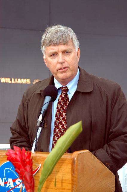 KENNEDY SPACE CENTER, FLA. -  Center Director Jim Kennedy speaks to attendees at a memorial service honoring the crew of Columbia.  He stands in front of the Space Memorial Mirror at the KSC Visitor Complex.  Feb. 1 is the one-year anniversary of the loss of the crew and orbiter Columbia in a tragic accident as the ship returned to Earth following mission STS-107.  Attended by many friends, co-workers and families, the memorial service was also open to the public.