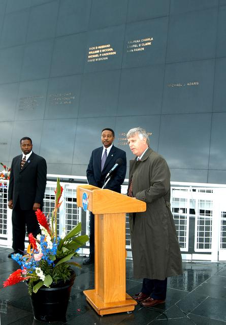 NASA image: KENNEDY SPACE CENTER, FLA. -  Center Director Jim Kennedy (right) speaks to attendees at a memorial service honoring the crew of Columbia.  At left are KSC Deputy Director Woodrow Whitlow Jr. and Executive Director of Florida Space Authority Winston Scott, who was an invited speaker.  Scott is a former astronaut who flew on Columbia in 1997.  They are standing in front of the Space Memorial Mirror at the KSC Visitor Complex.  Feb. 1 is the one-year anniversary of the loss of the crew and orbiter Columbia in a tragic accident as the ship returned to Earth following mission STS-107.  Attended by many friends, co-workers and families, the memorial service was also open to the public.