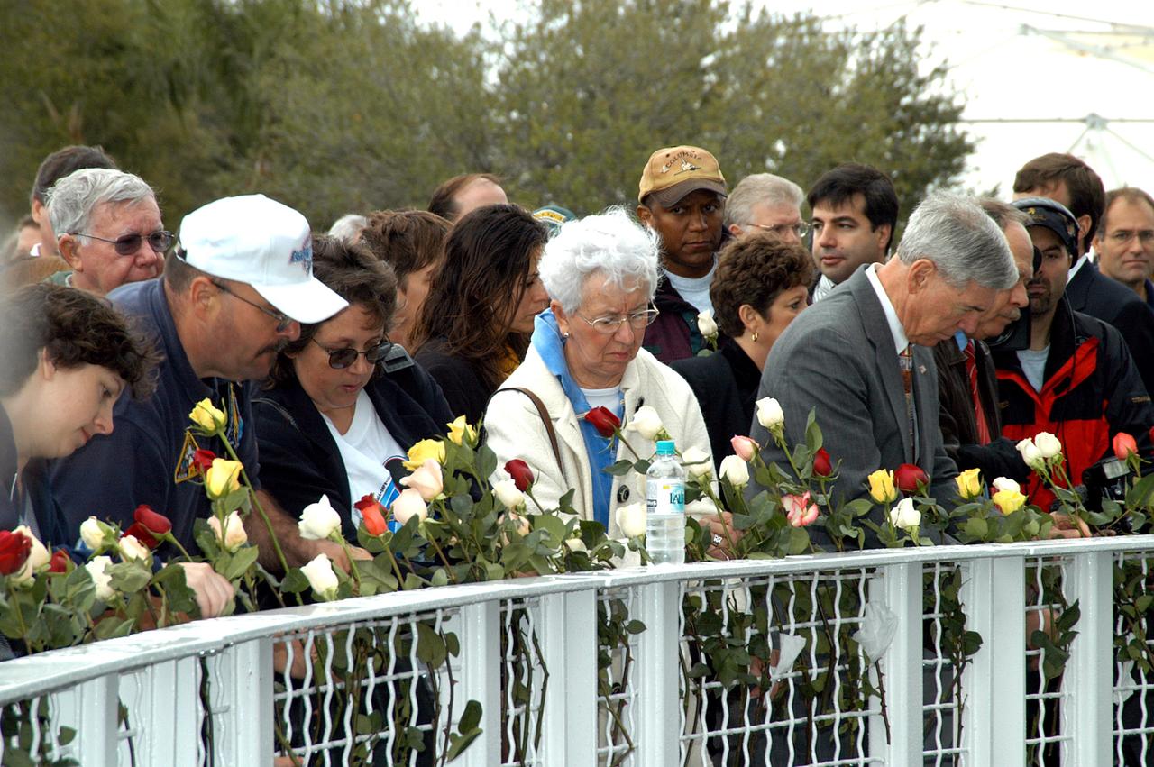 KENNEDY SPACE CENTER, FLA. -  Following the memorial service for the crew of Columbia at the Space Memorial Mirror, visitors place roses in the wire mesh fence surrounding the mirror.  Feb. 1 is the one-year anniversary of the loss of the crew and orbiter Columbia in a tragic accident as the ship returned to Earth following mission STS-107. The public was invited to the memorial service, held in the KSC Visitor Complex, which included comments by Center Director Jim Kennedy and Executive Director of Florida Space Authority Winston Scott.  Scott is a former astronaut who flew on Columbia in 1997.