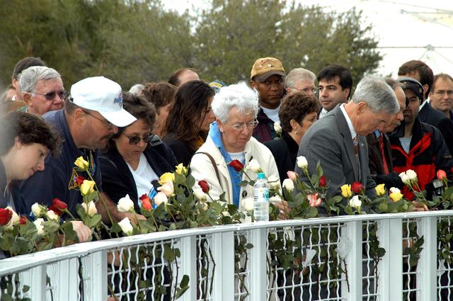 NASA image: KENNEDY SPACE CENTER, FLA. -  Following the memorial service for the crew of Columbia at the Space Memorial Mirror, visitors place roses in the wire mesh fence surrounding the mirror.  Feb. 1 is the one-year anniversary of the loss of the crew and orbiter Columbia in a tragic accident as the ship returned to Earth following mission STS-107. The public was invited to the memorial service, held in the KSC Visitor Complex, which included comments by Center Director Jim Kennedy and Executive Director of Florida Space Authority Winston Scott.  Scott is a former astronaut who flew on Columbia in 1997.