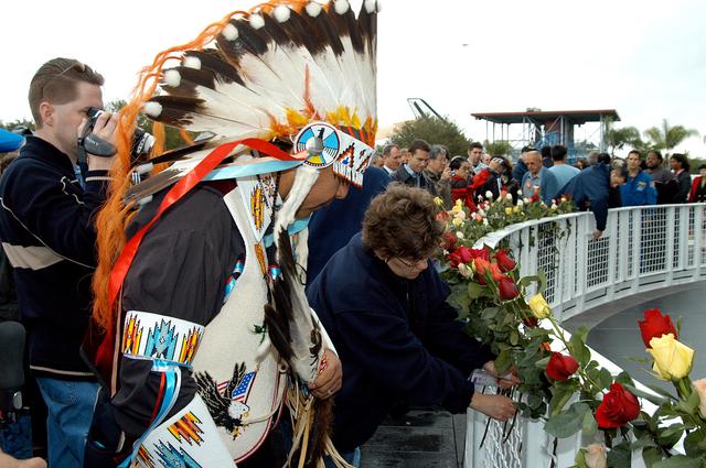 NASA image: KENNEDY SPACE CENTER, FLA. -  Among the visitors placing flowers in the wire mesh fence surrounding the Space Memorial Mirror is one of the Indian dancers who performed a healing ceremony during a memorial service for the crew of Columbia.  Feb. 1 is the one-year anniversary of the loss of the crew and orbiter Columbia in a tragic accident as the ship returned to Earth following mission STS-107. The public was invited to the memorial service, which included comments by Center Director Jim Kennedy and Executive Director of Florida Space Authority Winston Scott.  Scott is a former astronaut who flew on Columbia in 1997.