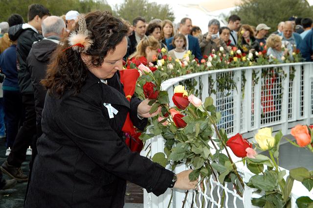 NASA image: KENNEDY SPACE CENTER, FLA. - Following the memorial service for the crew of Columbia at the Space Memorial Mirror, Louise Kleba, who is with United Space Alliance, joins other visitors placing roses in the wire mesh fence surrounding the mirror.  Feb. 1 is the one-year anniversary of the loss of the crew and orbiter Columbia in a tragic accident as the ship returned to Earth following mission STS-107. The public was invited to the memorial service, held in the KSC Visitor Complex, which included comments by Center Director Jim Kennedy and Executive Director of Florida Space Authority Winston Scott.  Scott is a former astronaut who flew on Columbia in 1997.