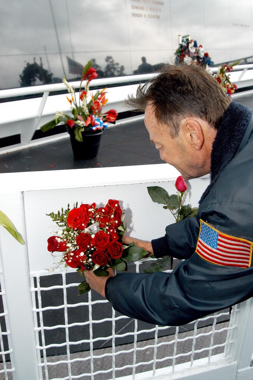 KENNEDY SPACE CENTER, FLA. -  Following the memorial service for the crew of Columbia at the Space Memorial Mirror, a visitor leaves a rose bouquet behind. Feb. 1 is the one-year anniversary of the loss of the crew and orbiter Columbia in a tragic accident as the ship returned to Earth following mission STS-107. The public was invited to the memorial service, held in the KSC Visitor Complex, which included comments by Center Director Jim Kennedy and Executive Director of Florida Space Authority Winston Scott.  Scott is a former astronaut who flew on Columbia in 1997.