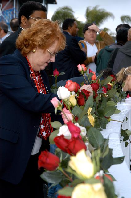 NASA image: KENNEDY SPACE CENTER, FLA. - Following the memorial service held at the Space Memorial Mirror for the crew of Columbia, visitors place roses in the wire mesh fence surrounding the mirror.  Feb. 1 is the one-year anniversary of the loss of the crew and orbiter Columbia in a tragic accident as the ship returned to Earth following mission STS-107. The public was invited to the memorial service, held in the KSC Visitor Complex, which included comments by Center Director Jim Kennedy and Executive Director of Florida Space Authority Winston Scott.  Scott is a former astronaut who flew on Columbia in 1997.