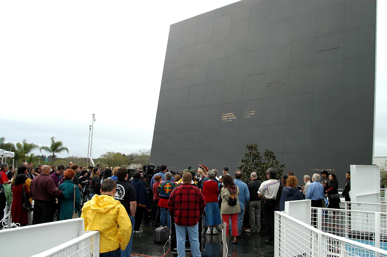 KENNEDY SPACE CENTER, FLA. - At the Space Memorial Mirror in the KSC Visitor Complex, visitors gather around dancers from the Shoshone-Bannock Native American community, Fort Hall, Idaho, who are performing a healing ceremony during the memorial service held for the crew of Columbia.  Feb. 1 is the one-year anniversary of the loss of the crew and orbiter Columbia in a tragic accident as the ship returned to Earth following mission STS-107.  Students and staff of the Shoshone-Bannock Nation had an experiment on board Columbia. The public was invited to the memorial service, held in the KSC Visitor Complex, which included comments by Center Director Jim Kennedy and Executive Director of Florida Space Authority Winston Scott.  Scott is a former astronaut who flew on Columbia in 1997.