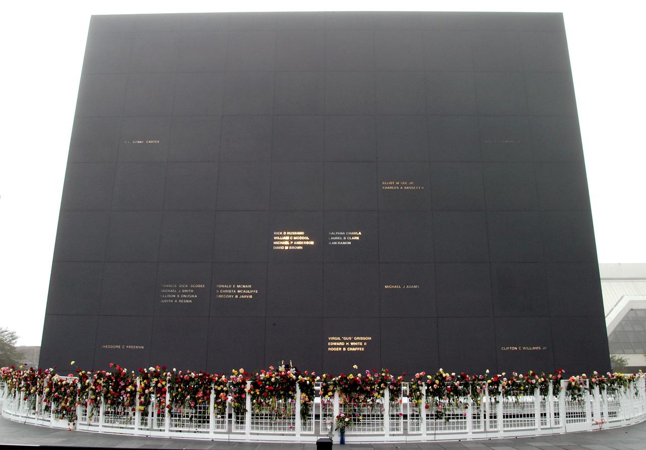 KENNEDY SPACE CENTER, FLA. - Roses and other flowers ring the base of the Astronaut Memorial Mirror at the KSC Visitor Complex following a memorial service held for the crew of Columbia on the anniversary of the tragic accident that took their lives Feb. 1, 2003.  The public was invited to the service and encouraged to place the flowers on the fence.  The service included comments by Center Director Jim Kennedy, Deputy Director Woodrow Whitlow Jr., Executive Director of Florida Space Authority Winston Scott, and Dr. Stephen Feldman, president of the Astronaut Memorial Foundation.  The black granite mirror honors astronauts, whose names are carved in the surface, who have given their lives for space exploration.